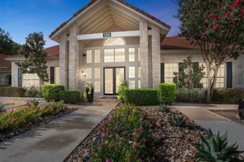 the front entrance of a building with a driveway and landscaping at The Olivine, Texas